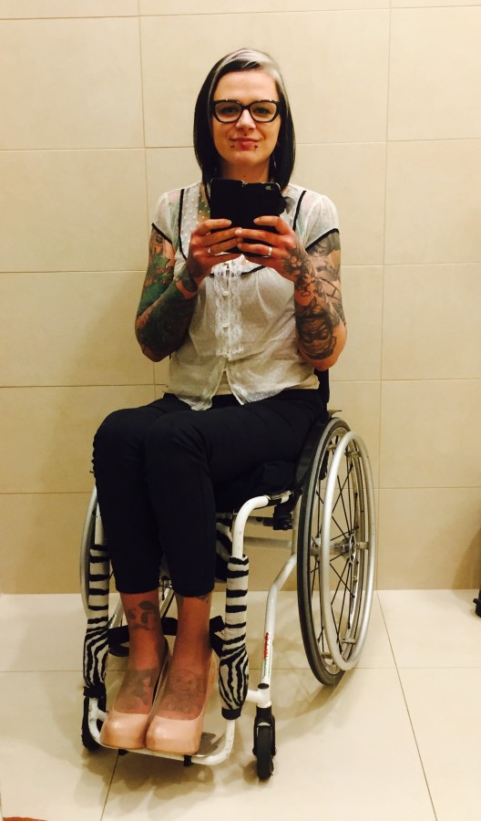  Izabela Sopalska-Rybak, prezeska Fundacji Kulawa Warszawa w eleganckim stroju, na wózku robi sobie zdjęcie w lustrze.