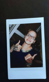 zdjęcie z polaroida z uśmiechającą się Izabelą Sopalską-Rybak, która ma kciuki uniesione do góry