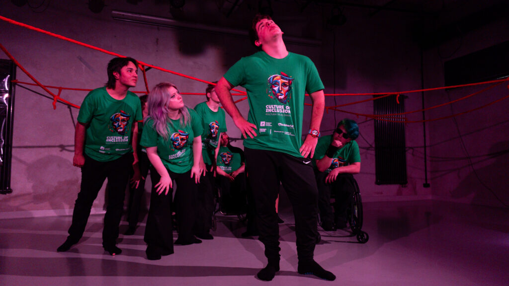 Scena w czasie spektaklu. Uczestnicy patrzą na młodego chłopaka patrzącego w sufit